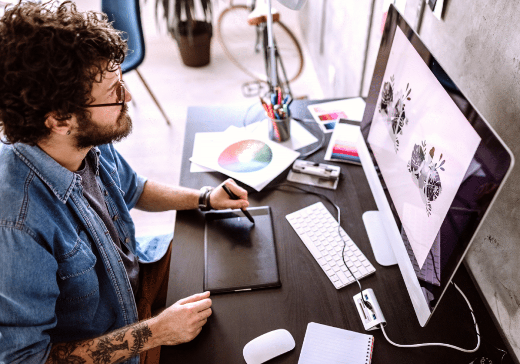 Digital artist working at a computer with a drawing tablet