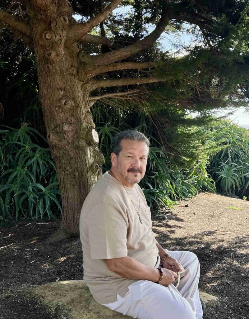 Man sitting in quiet reflection beneath a large tree