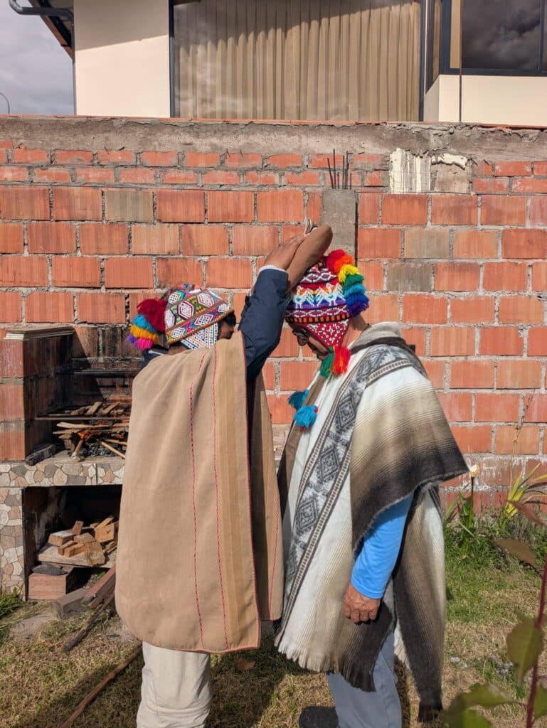 Andean healers in traditional ponchos performing a blessing ceremony