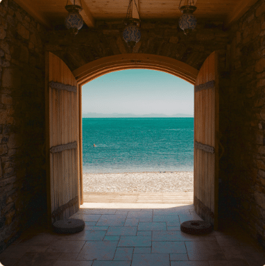 Open wooden doors framing a view of the ocean