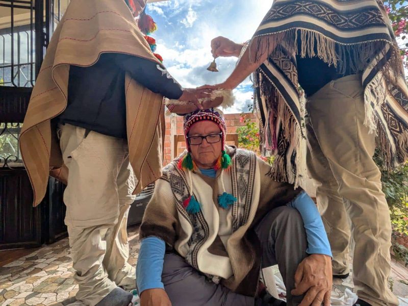Andean healers giving a blessing to a seated participant