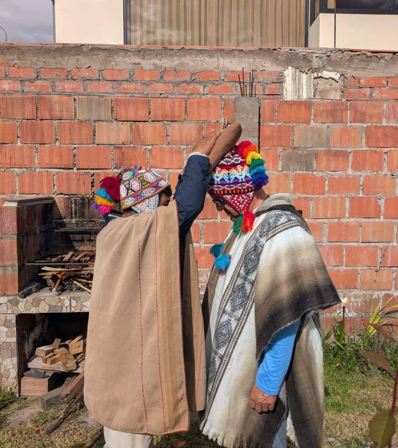 Andean healers in traditional ponchos performing a blessing ceremony
